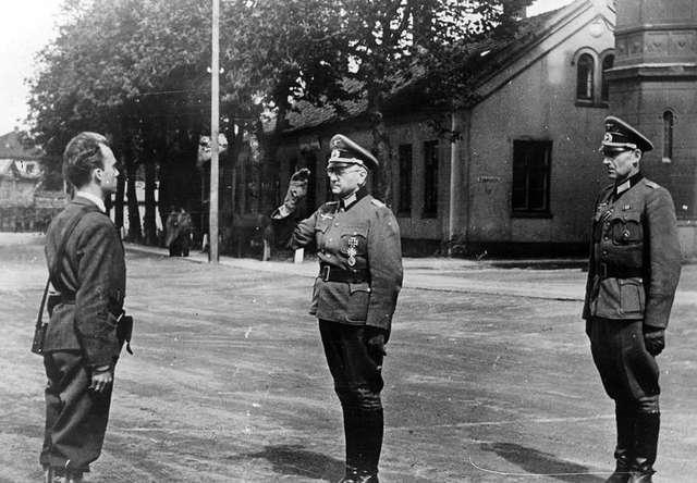 1945년 5월 11일 노르웨이 저항 운동가인 테르예 롤렘(맨 왼쪽)이 독일 가니슨 사령관 요제프 닉터라인(가운데) 소령과 그의 보좌관 요하네스 하멜에게서 요새 지휘권을 넘겨받고 있다.  출처=www.nb.no